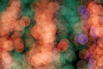 Wall Mural - Orange, red and green Christmas light shiny abstract round bokeh on dark background. Colourful Glitter bokeh from blurry decoration bulbs.