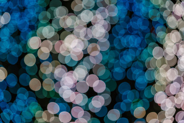 Wall Mural - Pink, gold and blue Christmas light shiny abstract round bokeh on black background. Colourful Glitter bokeh from blurry decoration bulbs.
