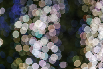 Wall Mural - Pink, gold and blue Christmas light shiny abstract round bokeh on black background. Colourful Glitter bokeh from blurry decoration bulbs.