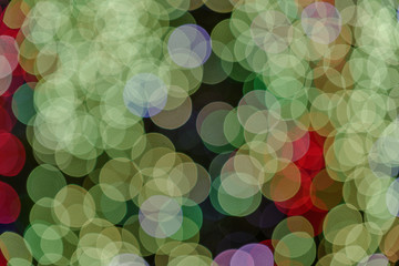 Wall Mural - Green red Christmas light shiny abstract round bokeh on black background. Colourful Glitter bokeh from blurry decoration bulbs.