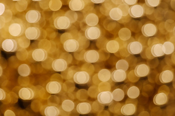 Wall Mural - Gold Christmas light shiny abstract round bokeh on dark background. Colourful Glitter bokeh from blurry decoration bulbs.