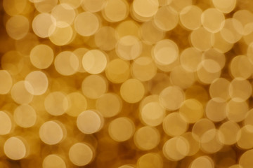 Wall Mural - Gold Christmas light shiny abstract round bokeh on dark background. Colourful Glitter bokeh from blurry decoration bulbs.