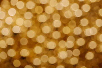 Wall Mural - Gold Christmas light shiny abstract round bokeh on dark background. Colourful Glitter bokeh from blurry decoration bulbs.