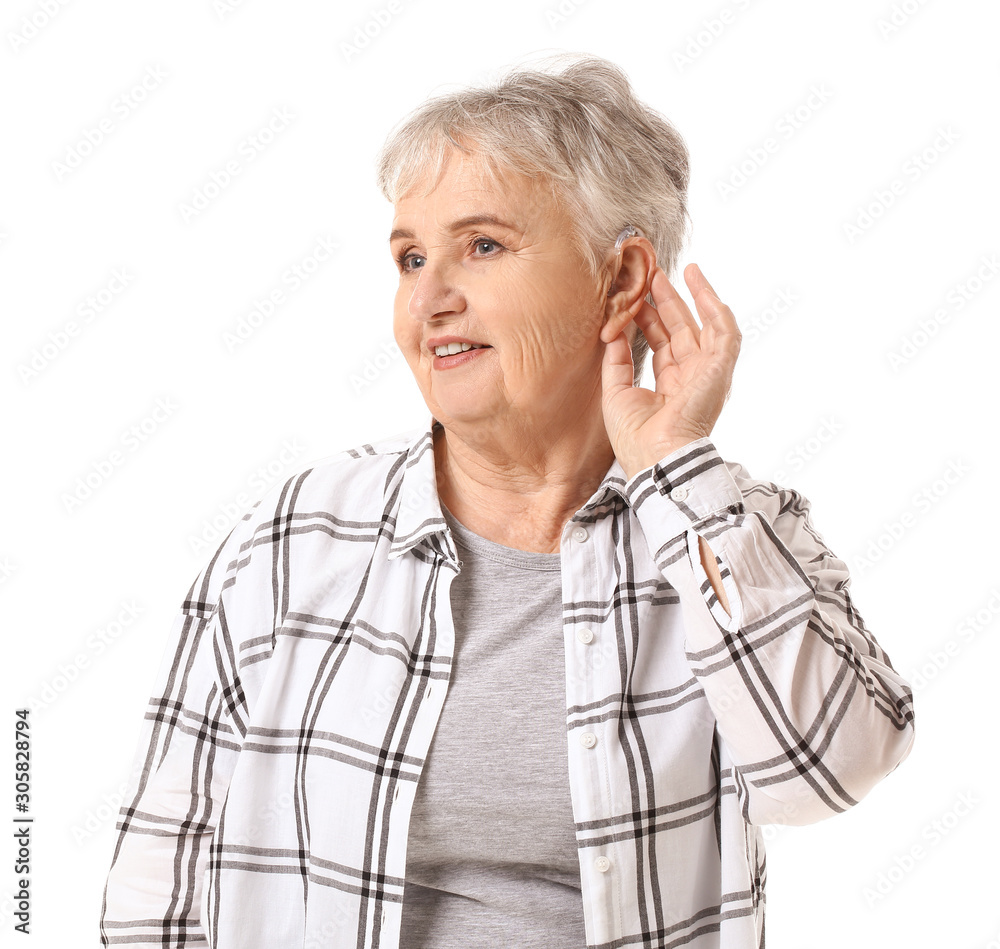Senior woman with hearing aid on white background