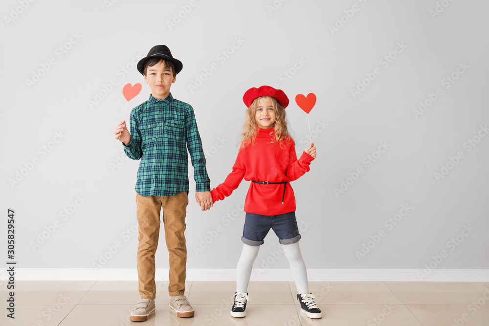 Cute little children with red hearts on grey background. Valentines Day celebration