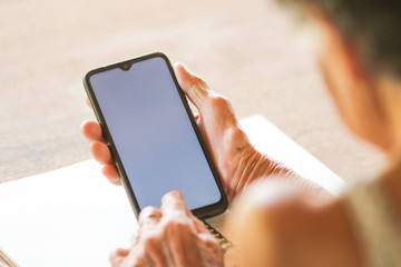 old woman holding smart phone for shpping online