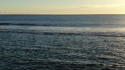 Wall Mural - moving towards skyline above ocean surf at sunset time
