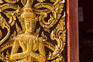 Closeup Golden Deva carve on door, Temple in Thailand.