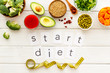 Start diet text near healthy food on white wooden background top view