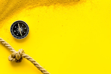 Wall Mural - Goal achievement concept. Compass near rope with knot on yellow background top view copy space