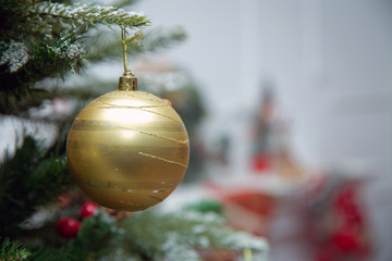 Branches Christmas gold ball . New year background decorations Christmas white tree green nature Christmas gold ball . Christmas ball hanging star abov . Red on a branch of a New Year's fir-tree .