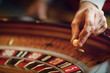 Hand of a croupier on a roulette whell in a casino.