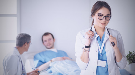 Wall Mural - Doctor checking heart beat of patient in bed with stethoscope