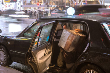 Wall Mural - Japanese man getting into taxi on rainy night　雨の夜にタクシーに乗り込む男性