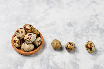 Quail eggs on a white-grey concrete  background