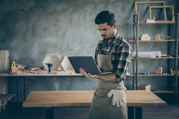 Photo of handsome guy holding notebook website administrator reading new orders checking email box wooden business industry woodwork shop garage indoors