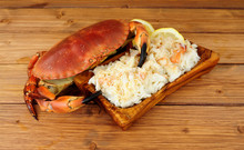 Whole Fresh Cooked Brown Crab And Fresh Meat In A Wood Dish On A Wooden Background With Lemon And Salad Leaves
