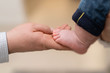 Dziecięca stopa w rękach rodzica
