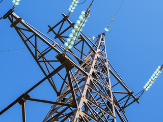 Metal pillars of power lines close up against the blue sky