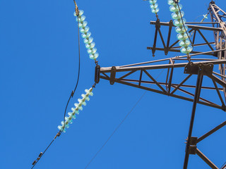 Metal pillars of power lines close up against the blue sky