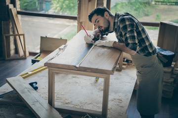 Wall Mural - Concentrated workman man restore wooden slab table use pencil ruler measure length on desk surface in home house garage