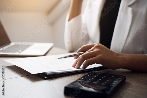 Fotografía Women are sitting analyzing the company's financial statement plan using a calculator on his desk