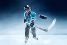Young Female Hockey Player With The Stick On Ice Court And Blue Background. Sportswoman Wearing Equipment And Helmet Practicing. Concept Of Sport, Healthy Lifestyle, Motion, Movement, Action.