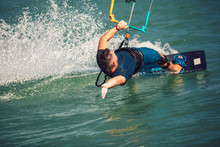 Professional Kiter Makes The Difficult Trick On A River. Kitesurfing Kiteboarding Action Photos Man Among Waves Quickly Goes
