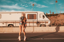 Retro Style Skater Girl With A Camper Van In The Background. California Lifestyle