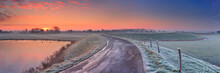 Typical Dutch Landscape With A Dike, In Winter At Sunrise