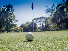 Photo Of White Golf Ball On Grass With Blue Sky Background