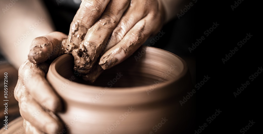 Hands of potter making clay pot on black background - obrazy, fototapety, plakaty 