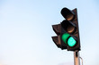 green traffic light with blue sky background