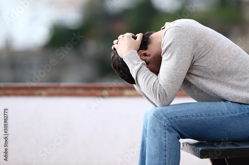 Fotomural Profile of a sad man complaining sitting on a bench