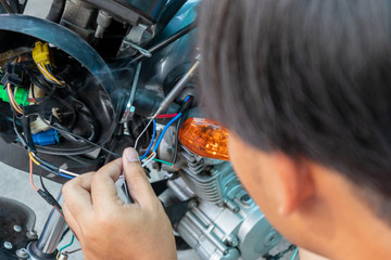 Fix or repair motorcycle lamp in garage. Soldering of electronic copper wires. Repair or maintenance concept.