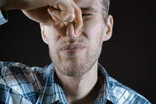 Man Close His Nose On Dark Background, Stink Smell, Fells Disgusting Sweat