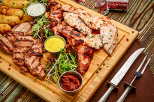 Assorted Delicious Grilled Meat And Vegetables With Fresh Salad And Bbq Sauce On Cutting Board On Wooden Background. Big Set Of Hot Meat Dishes