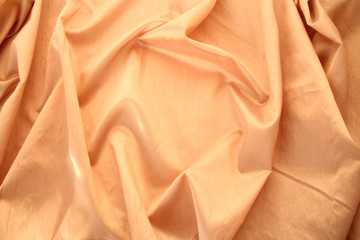 Wall Mural - beautiful silk fabric of delicate doggie color, light orange, draped with small folds, softly flowing, luxurious, wedding concept, texture, background, card form, copy space