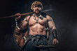 © Fxquadro - Severe barbarian in warrior clothes, posing on a dark background.