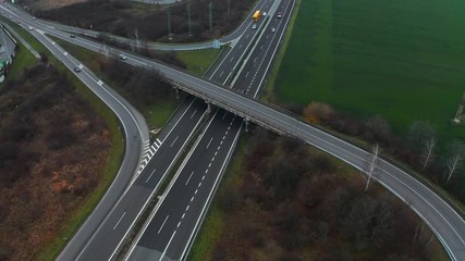 Wall Mural - Aerial view of a motorway. Static camera with view on cars running on the highway and the road. A lot of vehicles ride on the four lanes freeway