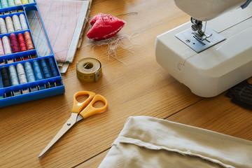 Work-space for sewing at home with sewing machine and sewing accessories on table