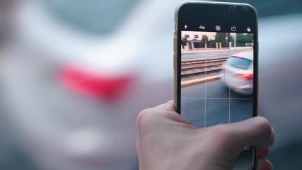 Poster - A closeup of a mobile phone screen that shoots video of passing cars.