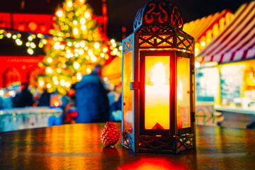 Wall Mural - Street lamp with candle at Christmas Market at Gendarmenmarkt square in Winter Riga, Latvia. Advent Fair Decoration and Stalls with Crafts Items on the Bazaar. Latvian street Xmas and holiday