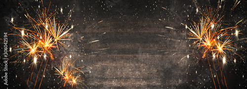 Cuadros en Lienzo Silvester background panorama long - Firework on rustic brown wooden texture wit