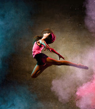 Street Dance Girl Dancer Jumping Up Dancing In Neon Light Doing Gymnastic Exercises In Studio On Dark Wall