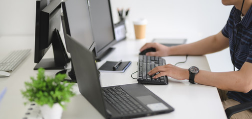 Young professional UI web developer working on his project with laptop computer