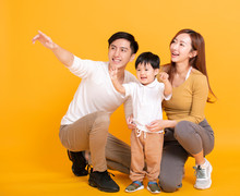 Happy Asian Family Looking Away And Pointing
