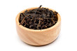 Dried fermented tea leaves in the wood bowl on a white background with clipping path.