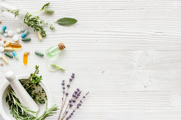 Wall Mural - Apothecary of natural wellness and self-care. Herbs and medicine on white wooden background top view frame copy space