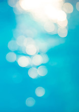 Bokeh Light Effects Over A Rippled, Blue Water Background
